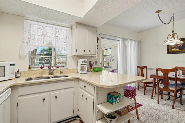 a room with a sink dishwasher a dining table and chairs with wooden floor