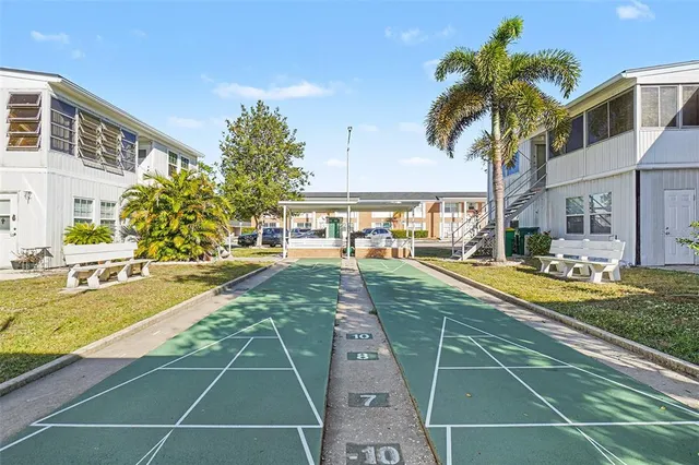 a view of a white house with a big yard and large tree