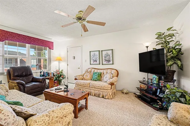 a living room with furniture a flat screen tv and a window