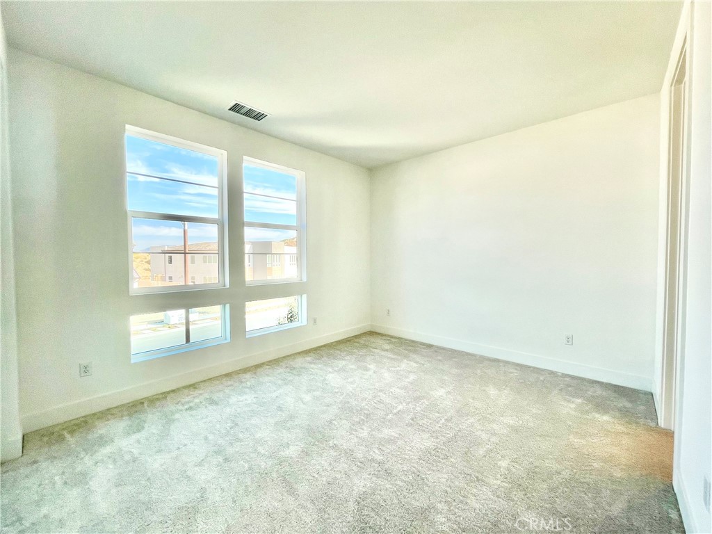 27557 Elderberry Drive Valencia, CA 91381 - Photo 28 of 39 an empty room with wooden floor and windows
