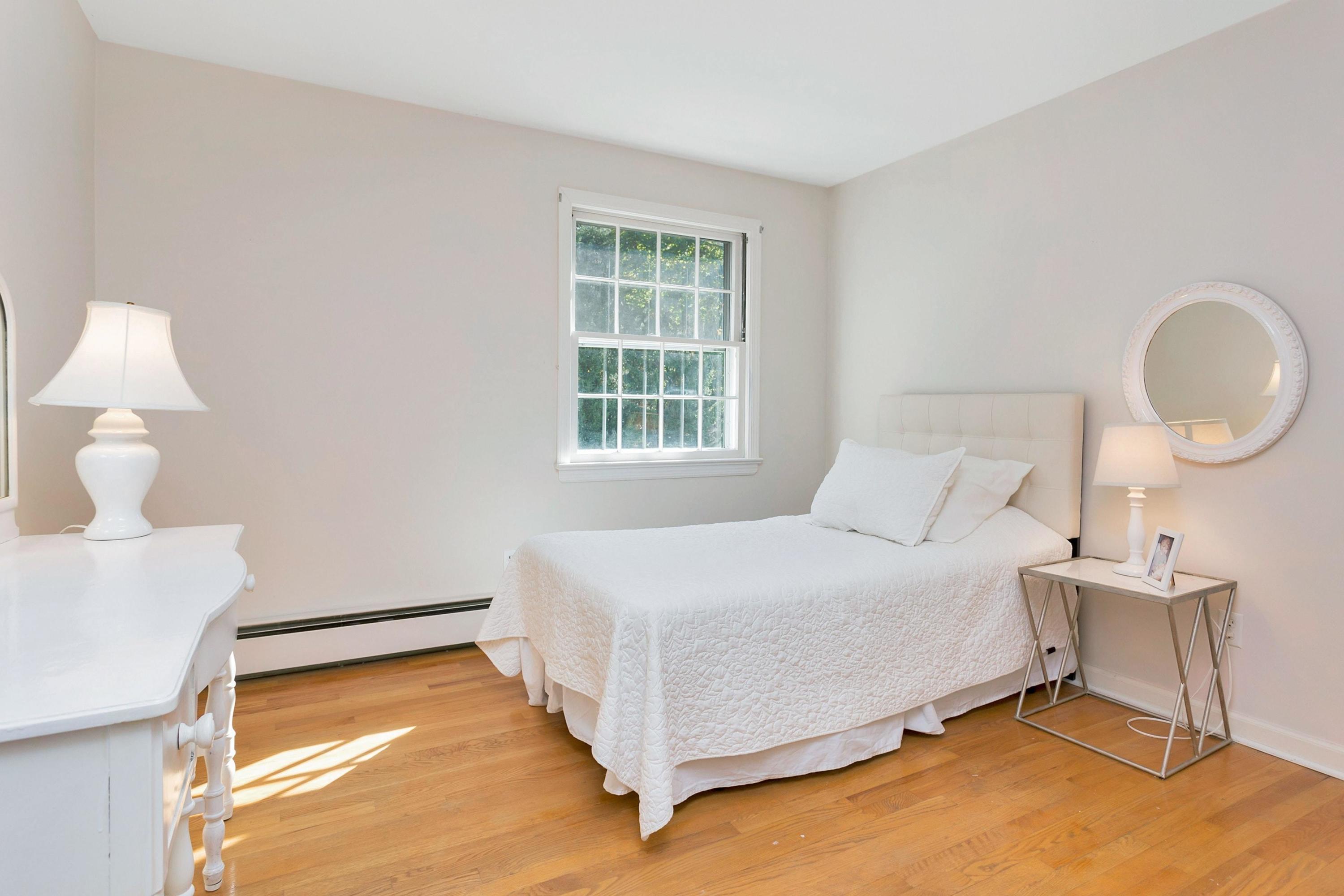 451 Middlesex Road Darien, CT 06820 - Photo 23 of 40 a bedroom with a bed lamp and a large window