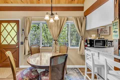 a dining room with furniture a chandelier and wooden floor