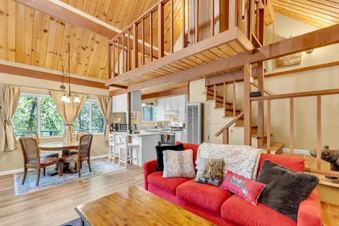a living room with furniture a large window and wooden floor