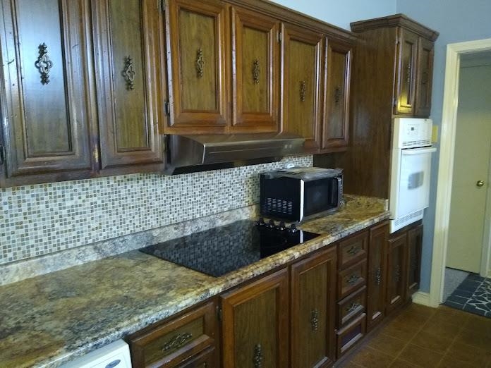 1435 East Holmes Road Memphis, TN 38116 - Photo 4 of 25 a kitchen with a granite countertop sink and cabinets