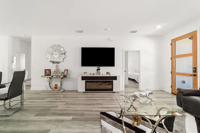 a living room with furniture and a wooden floor