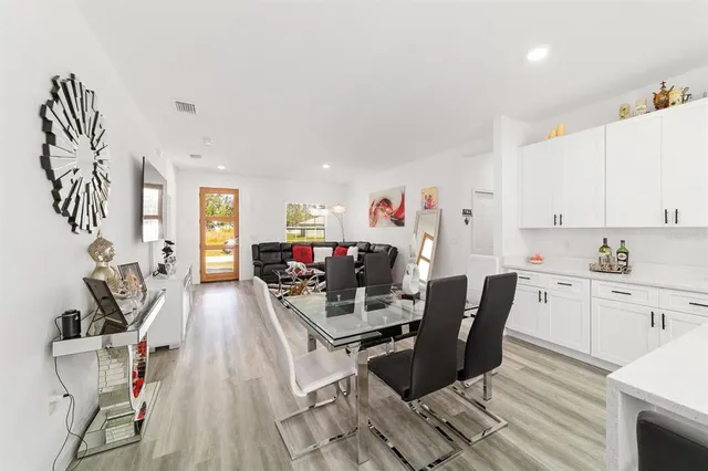 a kitchen with stainless steel appliances kitchen island granite countertop a sink dishwasher a stove a refrigerator a microwave oven with cabinets and wooden floor