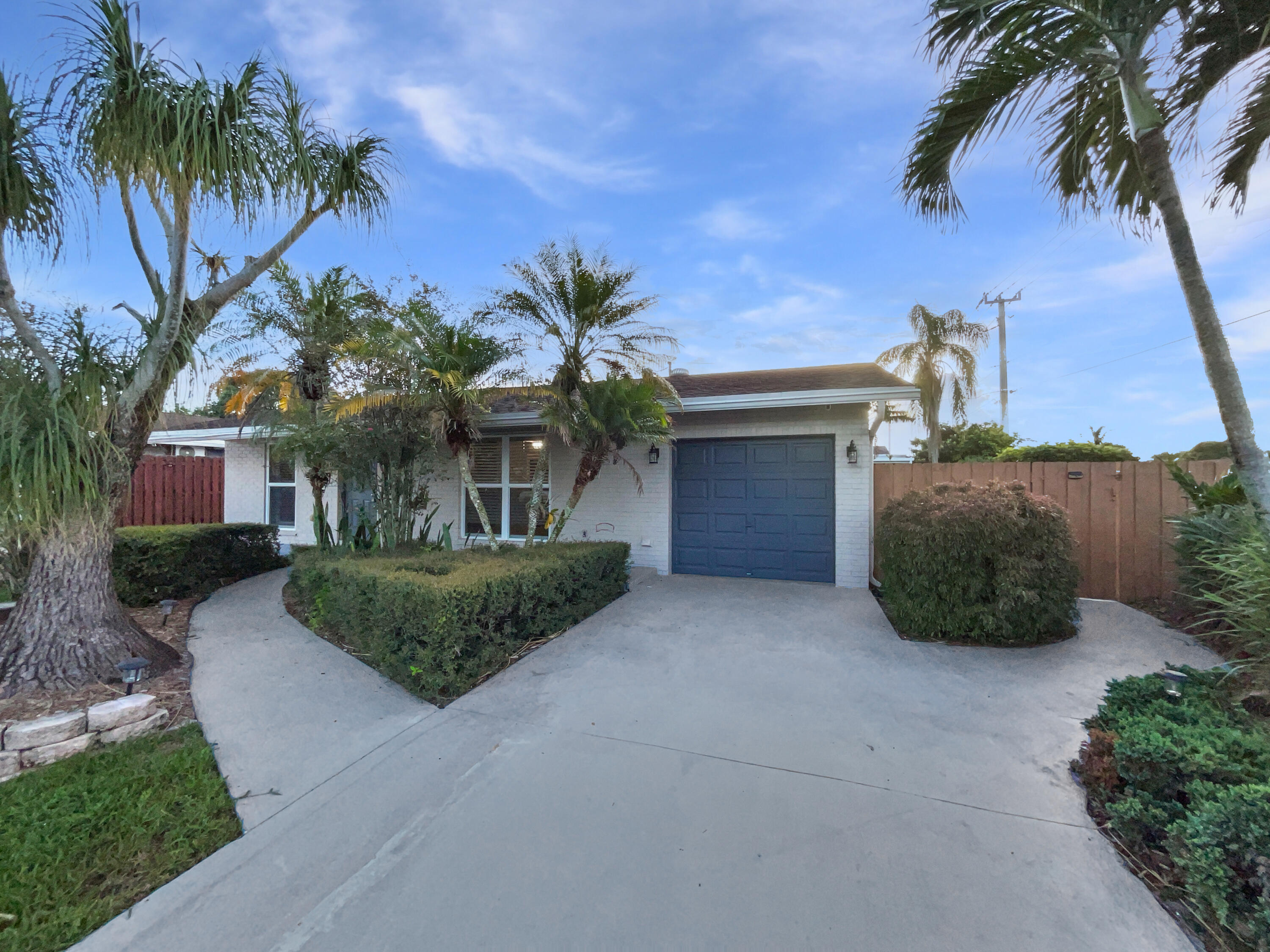 a front view of a house with a yard and palm tree
