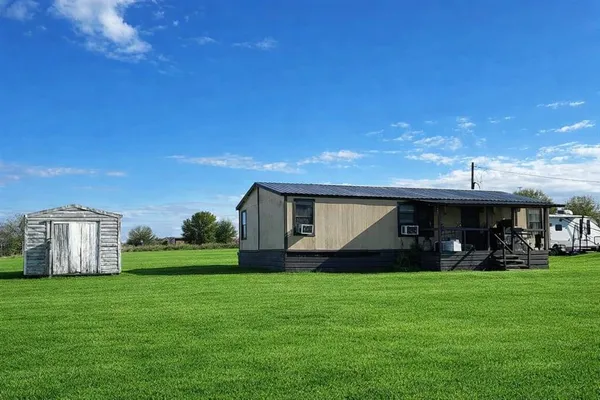 a view of a house with backyard and porch
