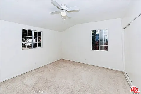 a view of a room with a window and a ceiling fan