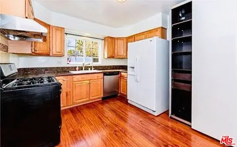 a kitchen with stainless steel appliances a sink a stove a microwave a counter top space and cabinets