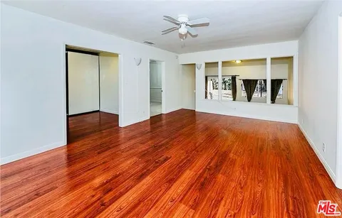 en empty room with windows and ceiling fan