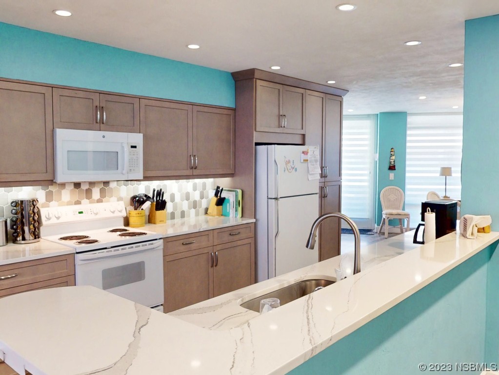 4555 South Atlantic Avenue, Unit 4502 Ponce Inlet, FL 32127 - Photo 11 of 54 a kitchen with white cabinets and stainless steel appliances