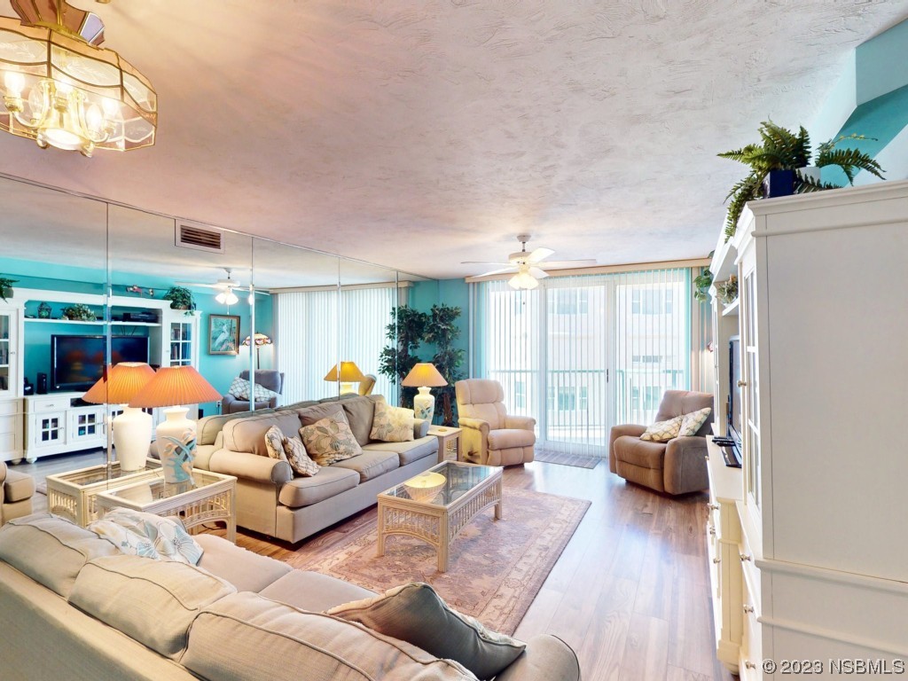 4555 South Atlantic Avenue, Unit 4502 Ponce Inlet, FL 32127 - Photo 13 of 54 a living room with furniture a large window and a chandelier