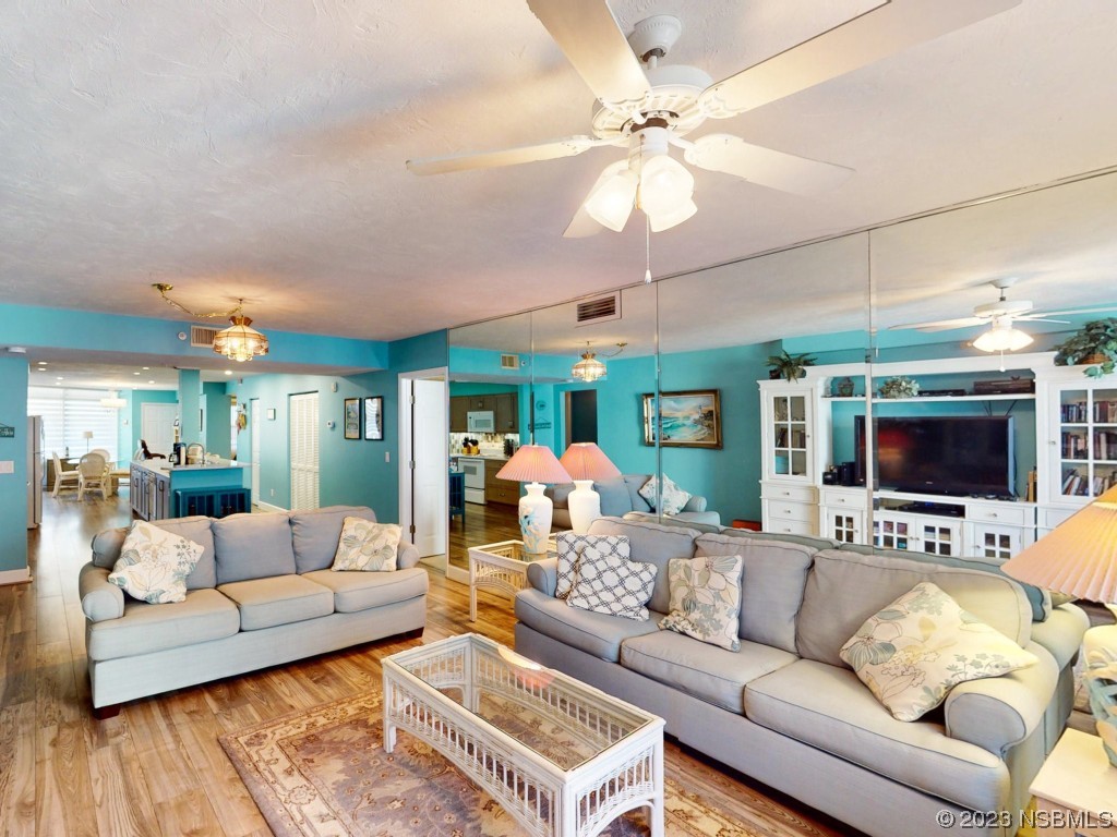 4555 South Atlantic Avenue, Unit 4502 Ponce Inlet, FL 32127 - Photo 14 of 54 a living room with furniture a flat screen tv and a chandelier