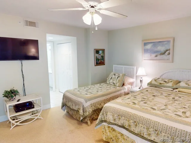 a bedroom with two beds and a flat screen tv