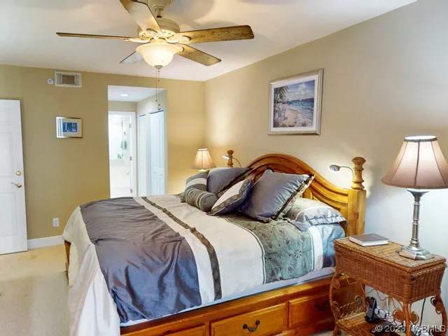 a bedroom with a bed and lamp on dresser