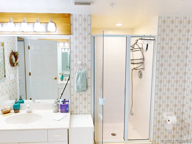a bathroom with a sink a mirror and a shower