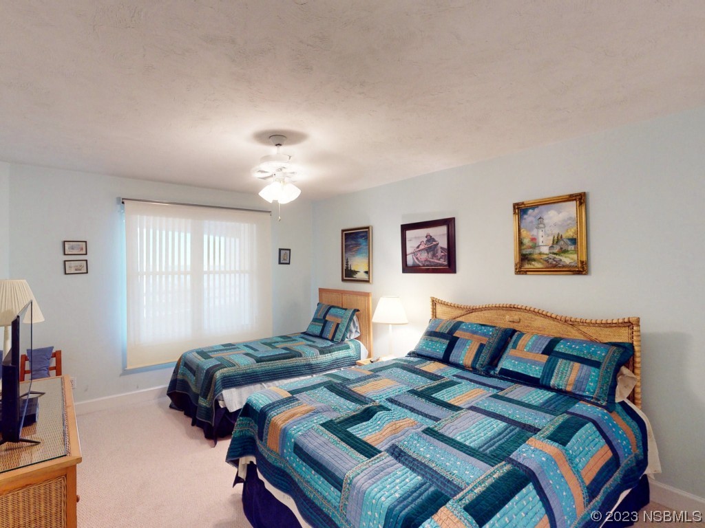 4555 South Atlantic Avenue, Unit 4502 Ponce Inlet, FL 32127 - Photo 32 of 54 a bedroom with two beds and a chandelier