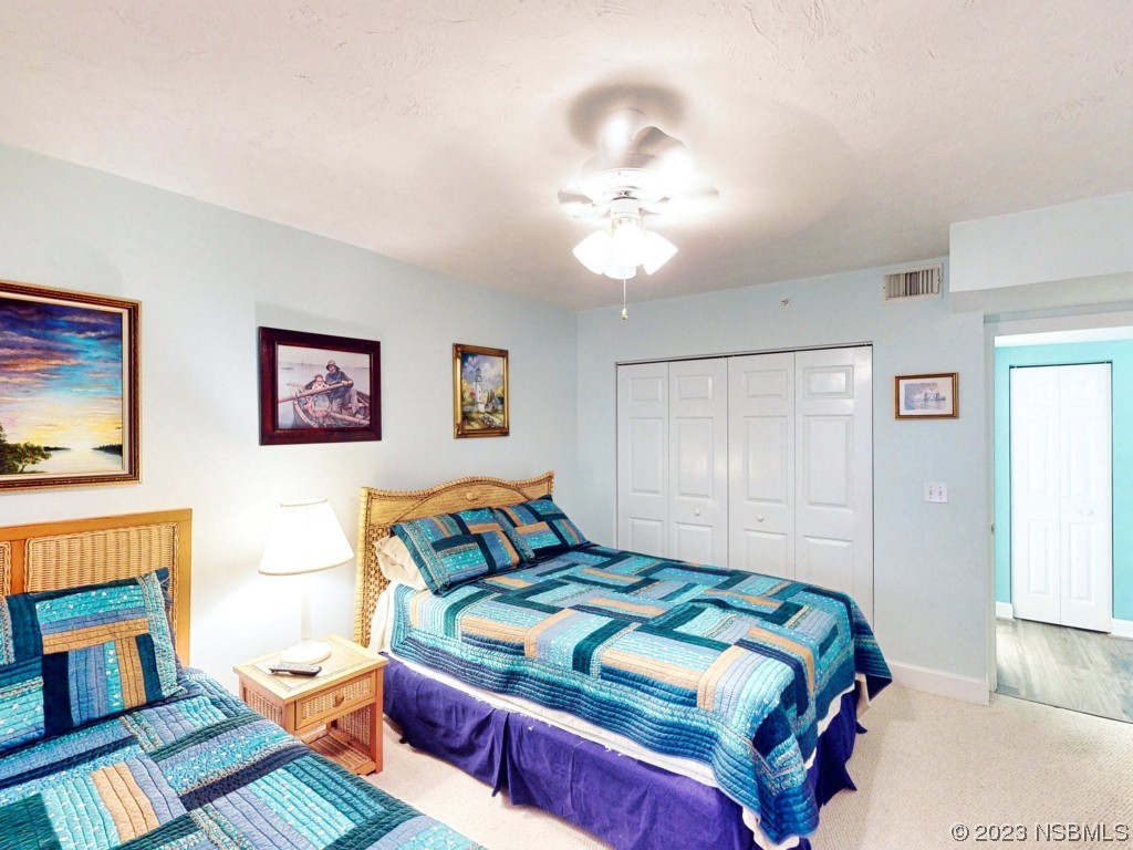 4555 South Atlantic Avenue, Unit 4502 Ponce Inlet, FL 32127 - Photo 34 of 54 a bedroom with a bed and a chandelier