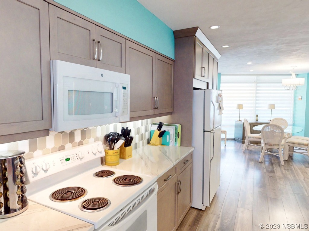 4555 South Atlantic Avenue, Unit 4502 Ponce Inlet, FL 32127 - Photo 8 of 54 a kitchen with a table chairs a stove and a refrigerator