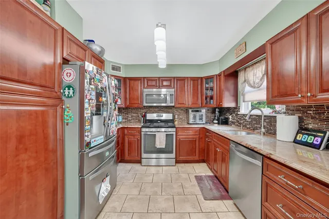 a kitchen with stainless steel appliances granite countertop a refrigerator a stove top oven a sink and dishwasher