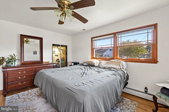 a bedroom with a bed and a dresser next to a window