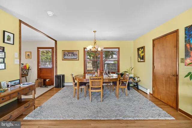 a dining room with wooden floor and window
