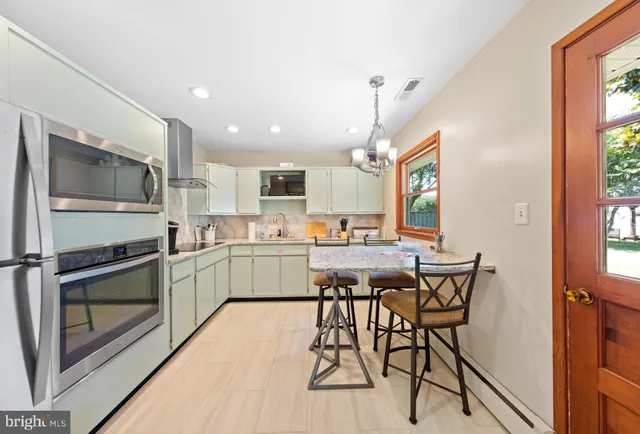 a kitchen with a table chairs refrigerator and cabinets