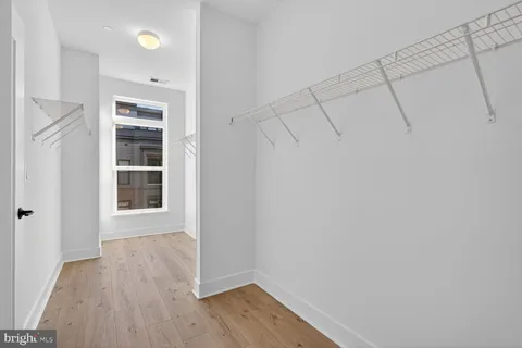 a view of a utility room with cabinets and wooden floor