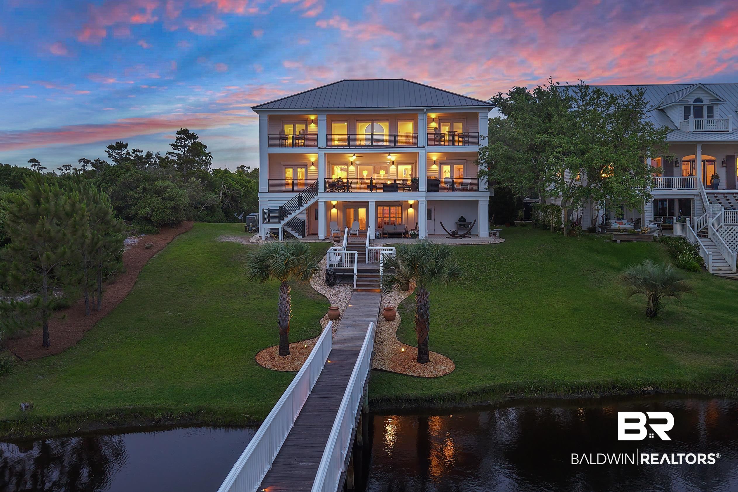 30954 River Road Orange Beach, AL 36561 - Photo 4 of 59 Rear view of property with stairs, a water view, a balcony, and a lawn
