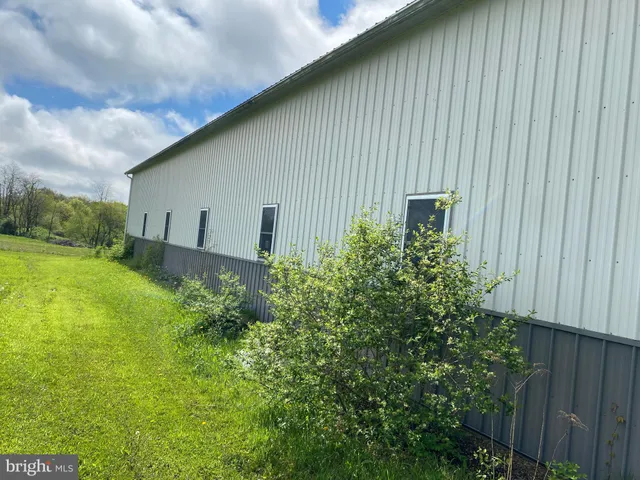 a view of a house with a yard and large trees