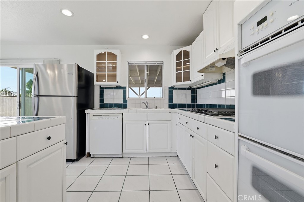 12755 Judd Street Pacoima, CA 91331 - Photo 5 of 46 a kitchen with white cabinets and appliances