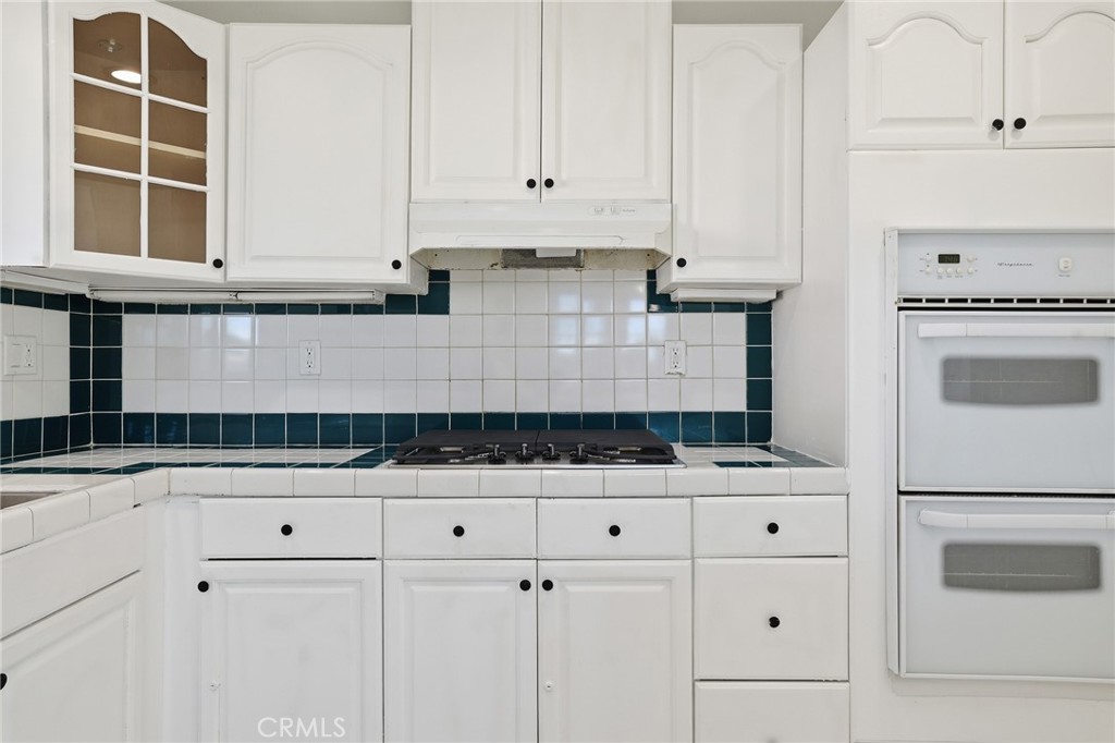 12755 Judd Street Pacoima, CA 91331 - Photo 9 of 46 a kitchen with granite countertop white cabinets and white appliances