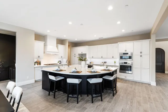 a kitchen with a dining table chairs and refrigerator