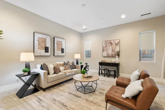 a living room with furniture and a wooden floor