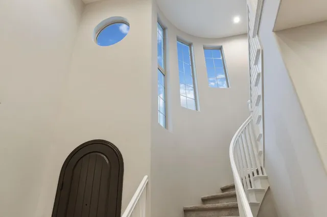 a view of staircase with railing and white walls