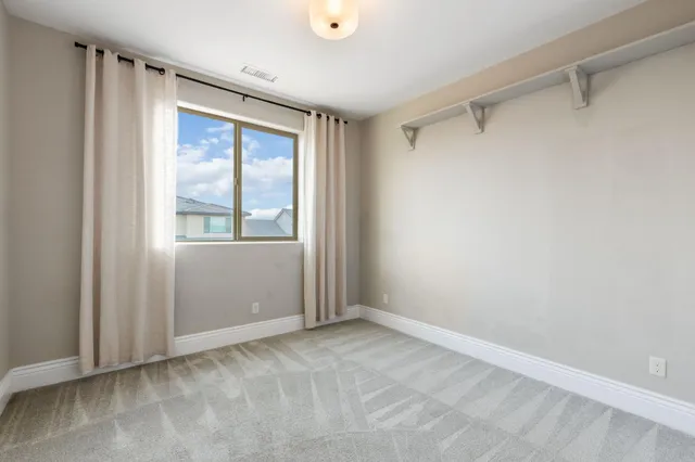 a view of a white house with a yard and table and chairs under an umbrella