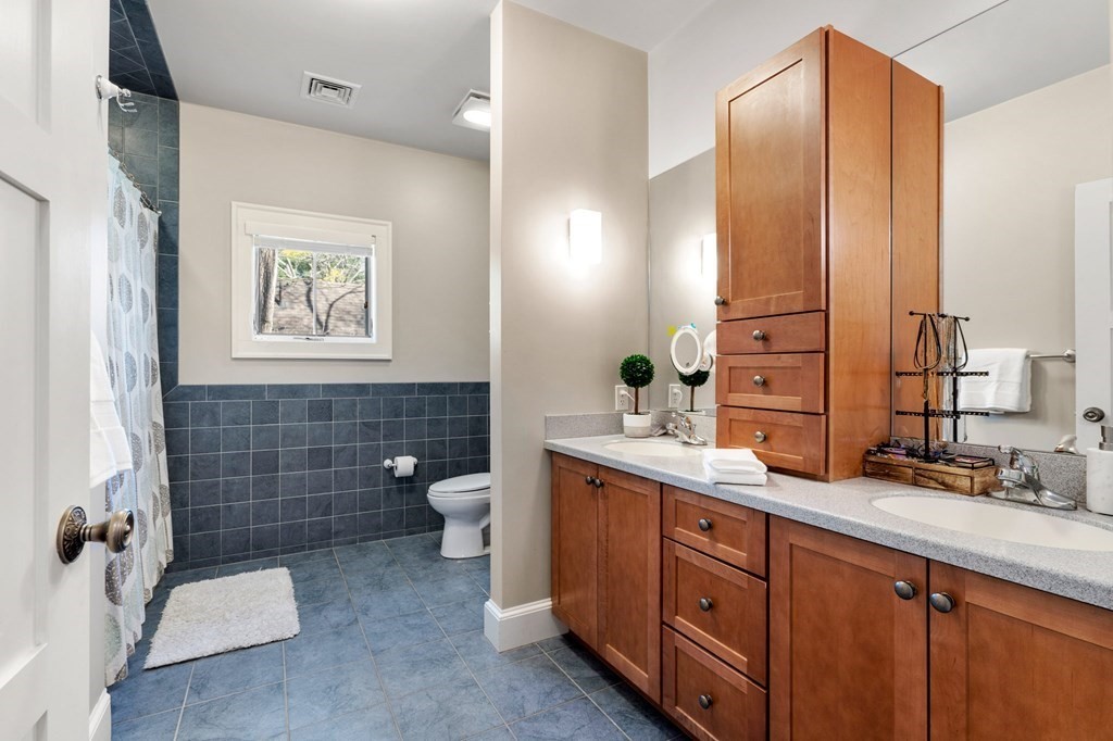 11 Wenham Road Newton, MA 02461 - Photo 16 of 19 a bathroom with a double vanity sink a toilet and a mirror