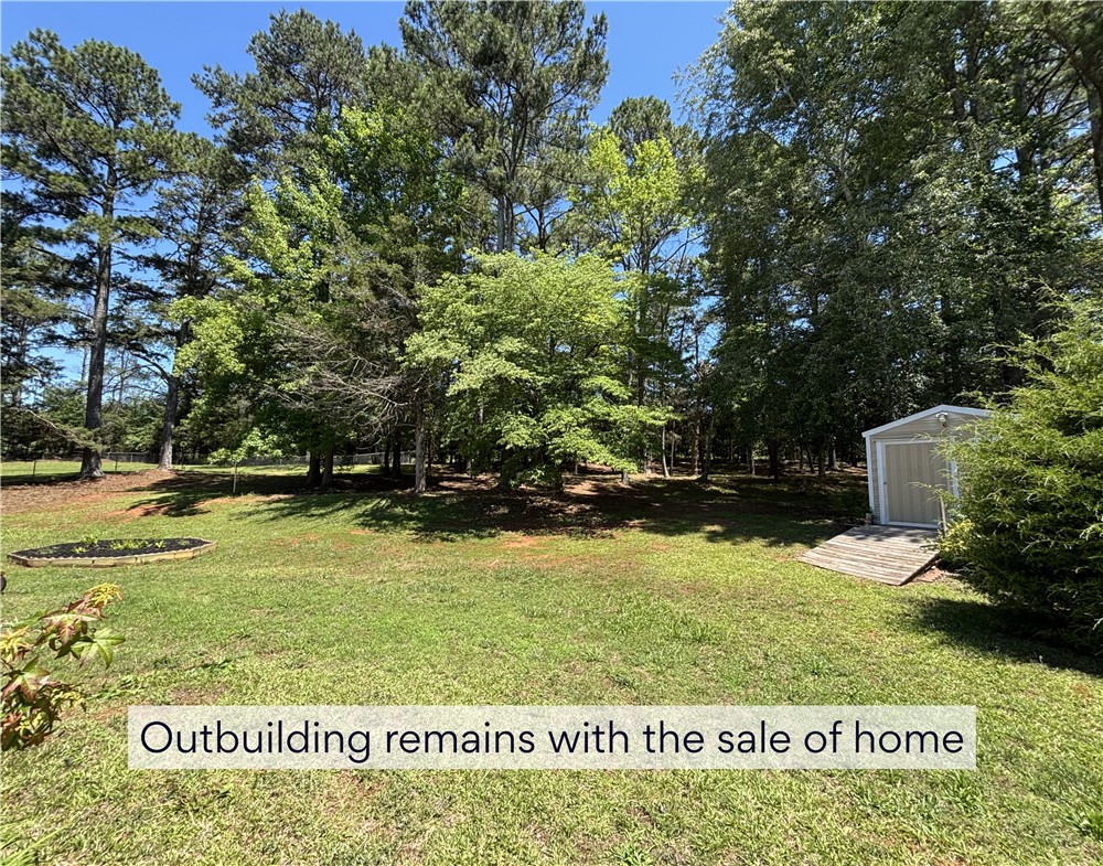 848 Perkins Creek Road Seneca, SC 29678 - Photo 25 of 26 A detached storage shed provides practical utility within a private, tree-lined yard.