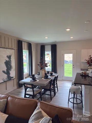 a view of a livingroom and dining room with furniture window and wooden floor