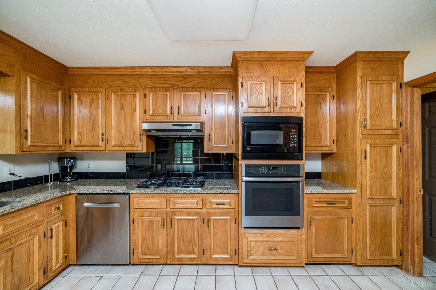 1796 Union Church Road Thaxton, VA 24174 - Photo 42 of 83 a kitchen with stainless steel appliances granite countertop a stove and a refrigerator