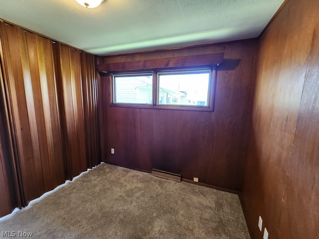 4061 Dartford Road Cleveland, OH 44121 - Photo 7 of 24 Unfurnished room featuring wooden walls and carpet flooring