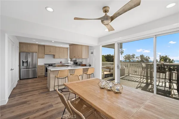 a dinning room and kitchen with a table chairs a ceiling fan