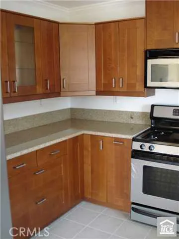 a kitchen with granite countertop cabinets stainless steel appliances and a counter space