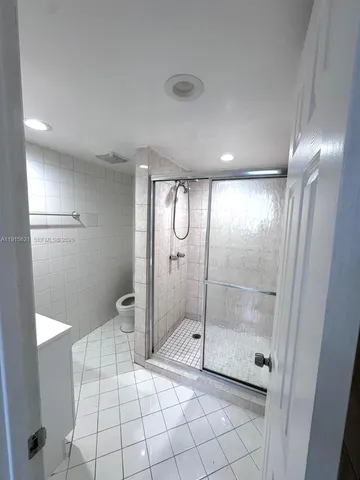 a bathroom with a glass shower door and a mirror