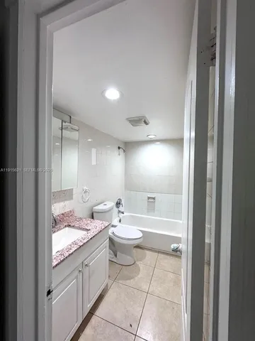 a bathroom with a granite countertop sink a toilet and shower