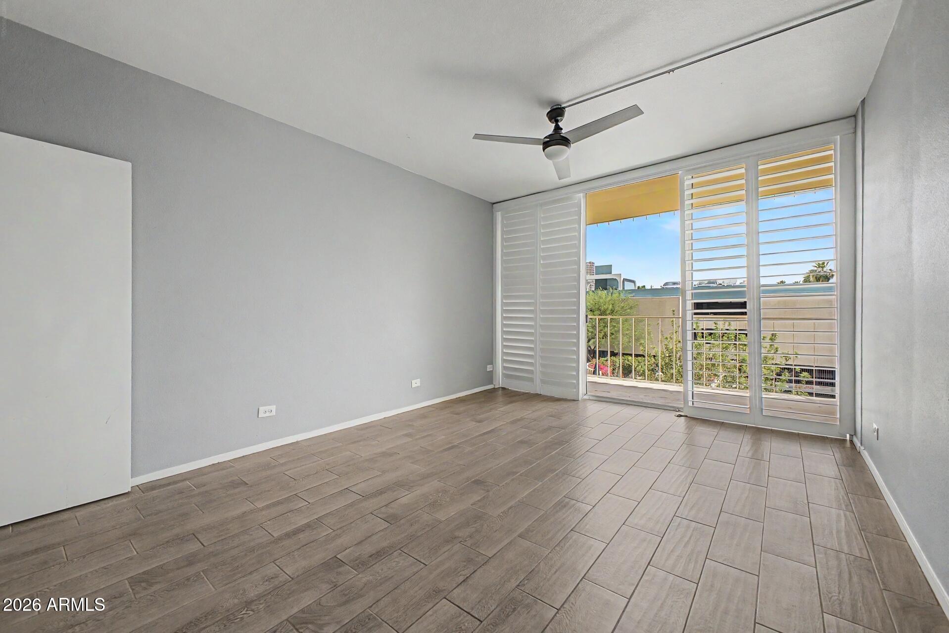 207 West Clarendon Avenue, Unit B2 Phoenix, AZ 85013 - Photo 9 of 30 a view of an empty room with wooden floor and a window