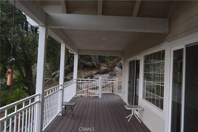 a view of a balcony with chairs and wooden floor