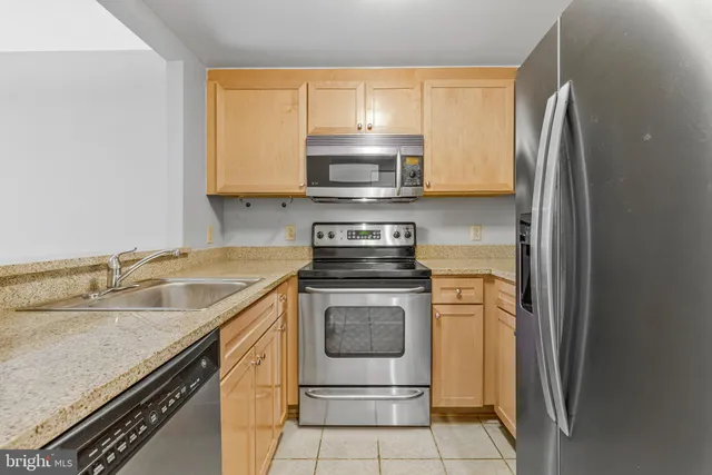 a kitchen with stainless steel appliances granite countertop a stove and a refrigerator