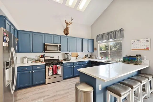 a kitchen with kitchen island granite countertop a sink stove and refrigerator